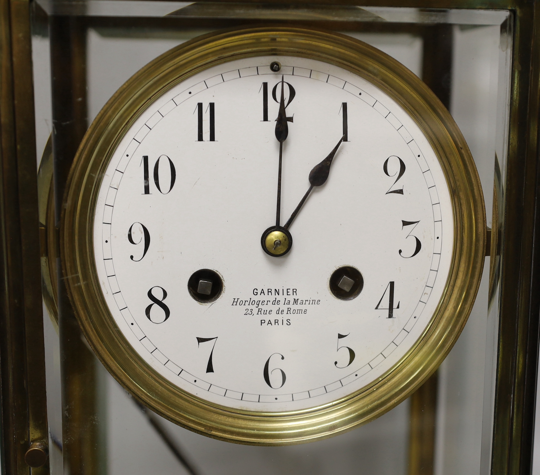 An early 20th century French brass four-glass mantel clock with enamel dial inscribed Garnier, 36cm high
